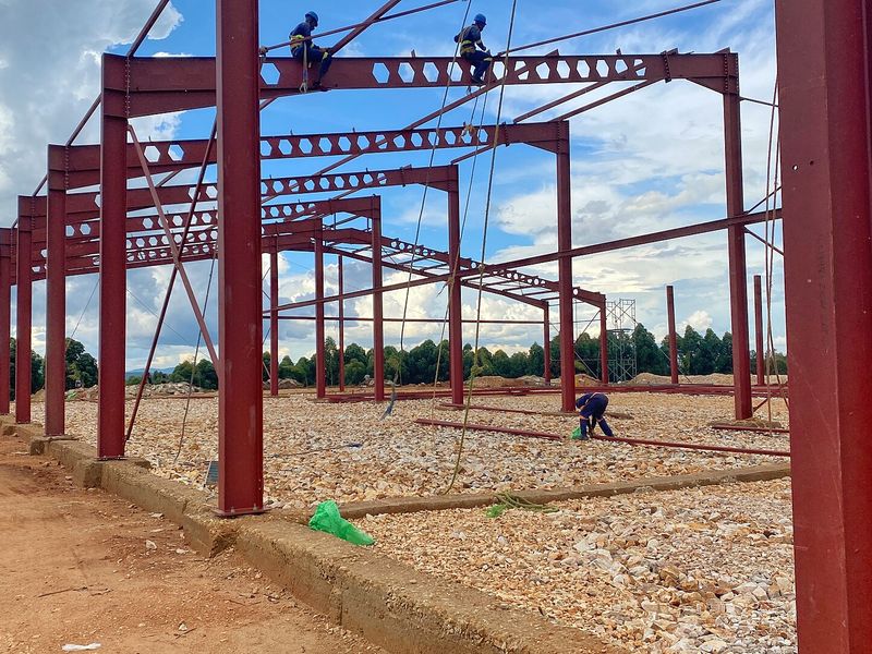 Workers fixing steel columns on a construction site in Uganda
